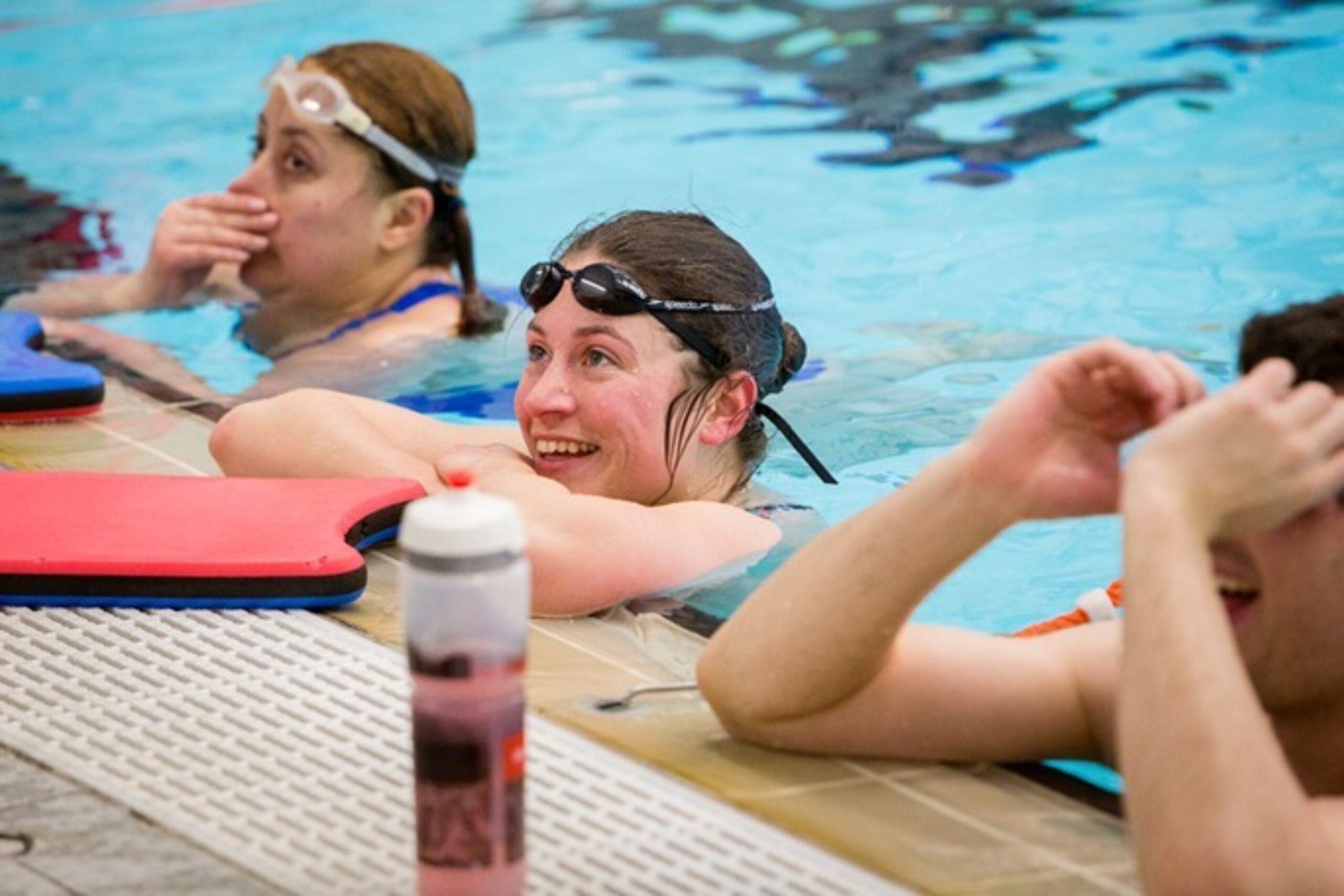 Adult female swimmers at the poolside.